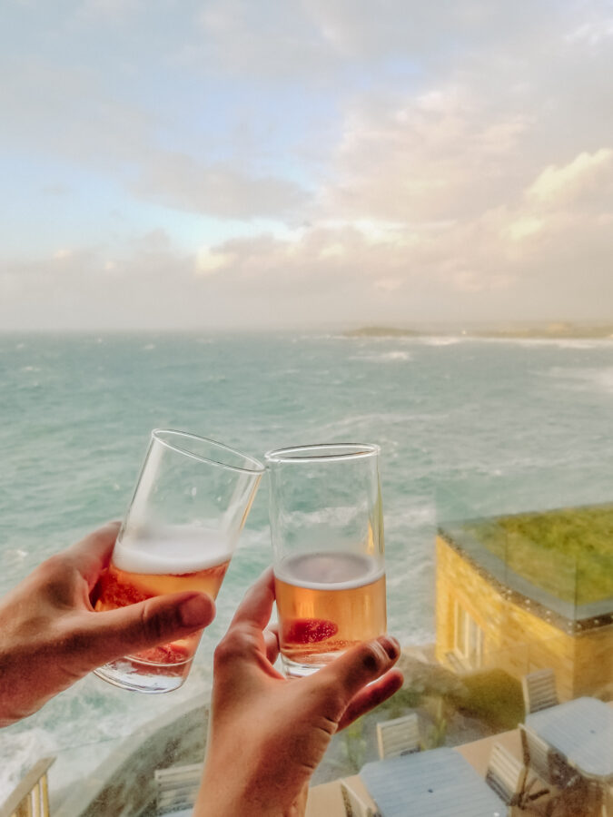 Couple tasting craft cider by the sea in Cornwall, Southern England
